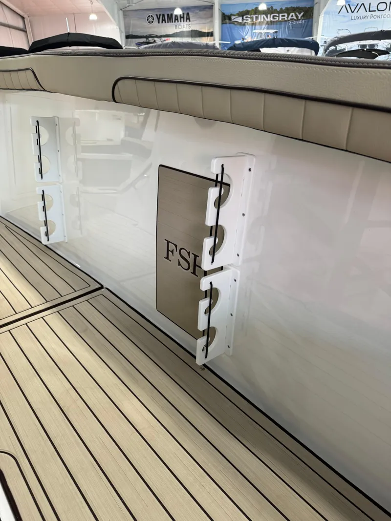 Slide: The Image of 2025 Yamaha Boats 255 FSH Sport E interior with sleek design and wood-patterned flooring. - 10