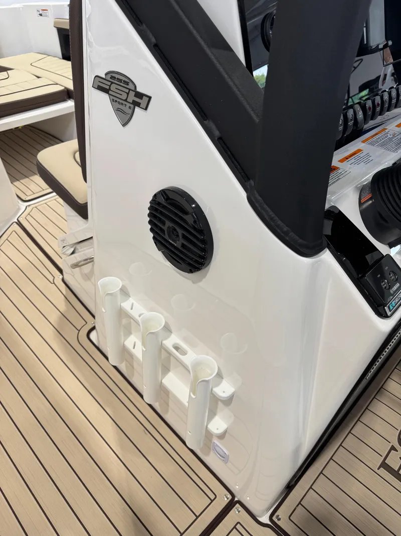 Slide: The Image of 2025 Yamaha Boats 255 FSH Sport E interior with rod holders and speaker. - 14