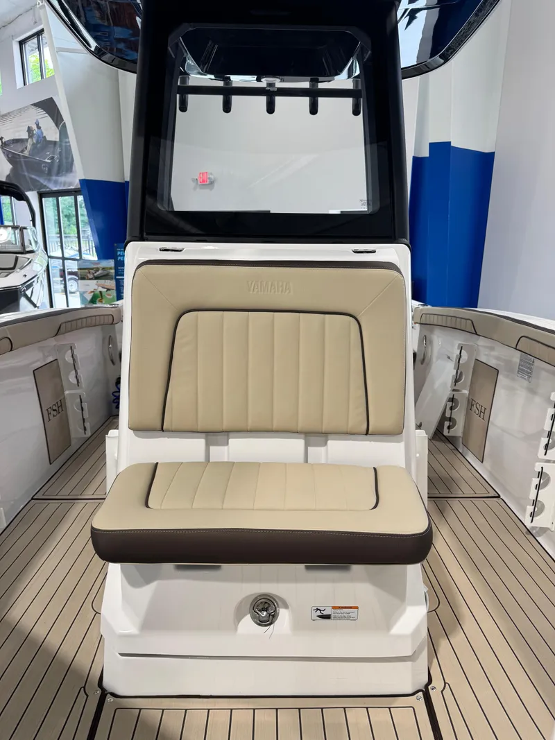 Slide: The Image of 2025 Yamaha Boats 255 FSH Sport E interior with beige seating and sleek design. - 17