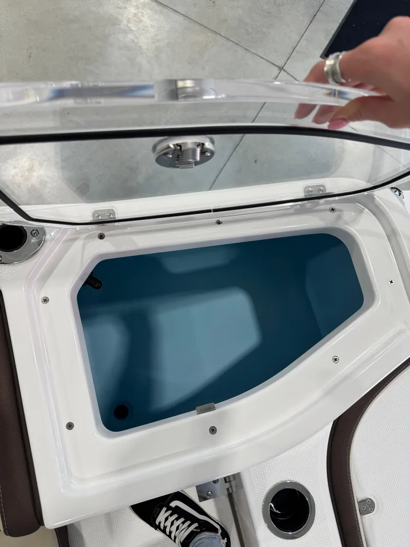 Slide: The Image of 2025 Yamaha Boats 255 FSH Sport E storage compartment with open lid, showcasing interior space. - 7