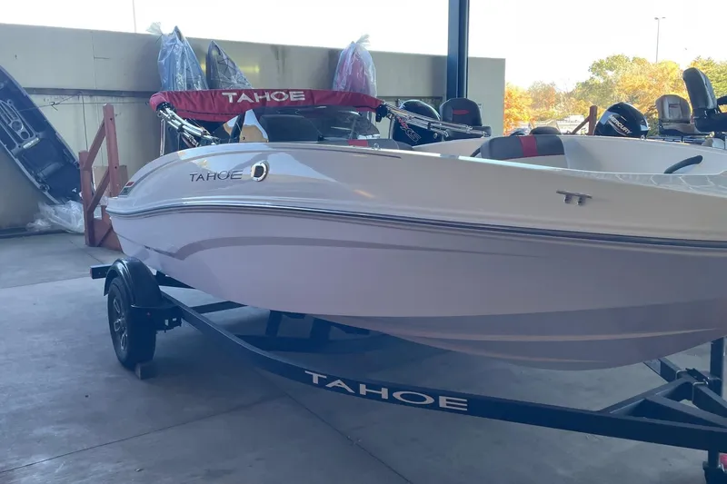 The Image of 2025 Tahoe T16 boat on trailer in a garage setting. - 0