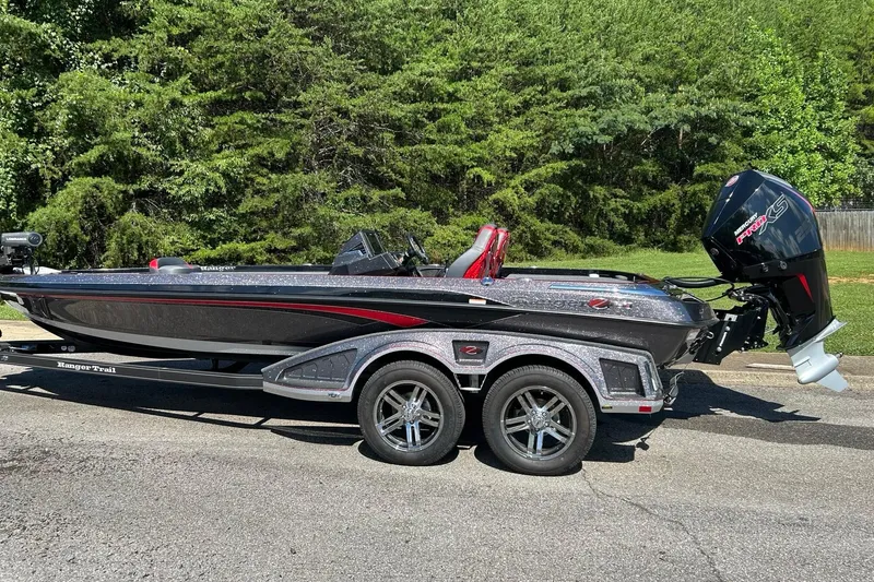 The Image of 2025 Ranger Z521R Cup-Equipped boat on trailer, parked outdoors with lush greenery background. - 0