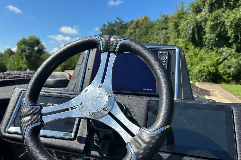 Slide: The Image of 2025 Ranger Z521R Cup-Equipped boat steering wheel and dashboard under clear blue sky. - 90