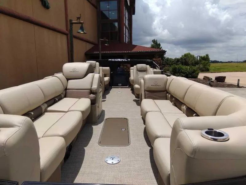 Slide: The Image of 2025 Regency 250 LE3 pontoon boat with luxurious beige seating and spacious deck. - 2