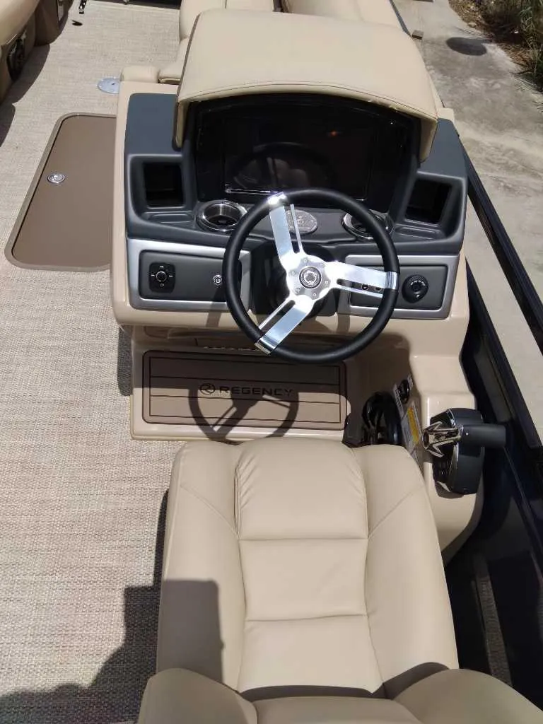 Slide: The Image of 2025 Regency 250 LE3 boat cockpit with beige seating and modern steering wheel. - 4