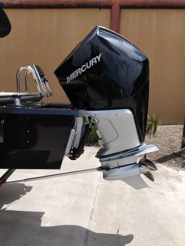 Slide: The Image of 2025 Regency 250 LE3 boat with Mercury outboard motor, parked on concrete surface. - 5
