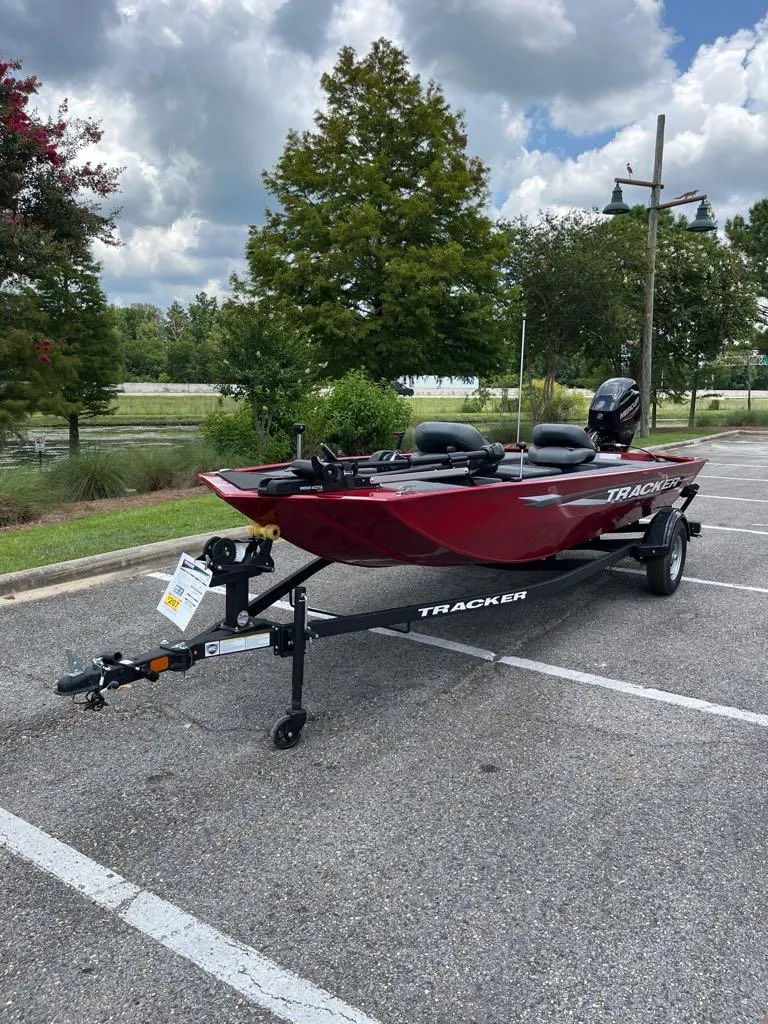 Slide: The Image of 2025 Tracker Panfish 17 boat on trailer in parking lot, surrounded by trees. - 7