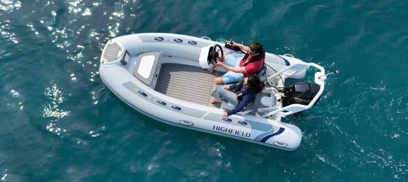 The Image of 2025 Highfield Classic 400 boat on clear blue water, two people onboard. - 1