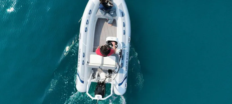 Slide: The Image of 2025 Highfield Classic 400 boat cruising on clear blue water, aerial view. - 3