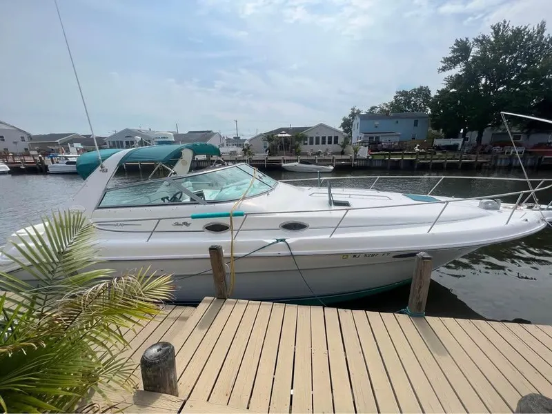 The Image of 1995 Sea Ray 330 Sundancer docked by waterfront homes. - 1