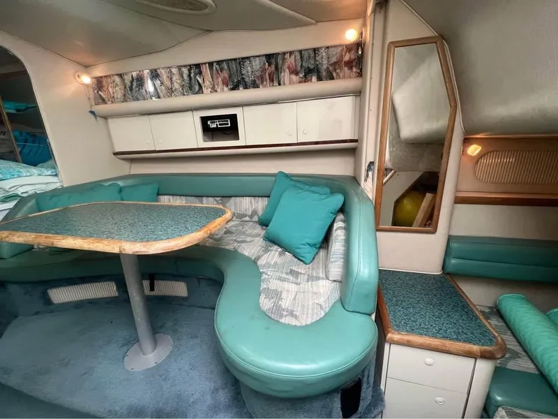 Slide: The Image of Interior of 1995 Sea Ray 330 Sundancer with teal seating and wooden table. - 11
