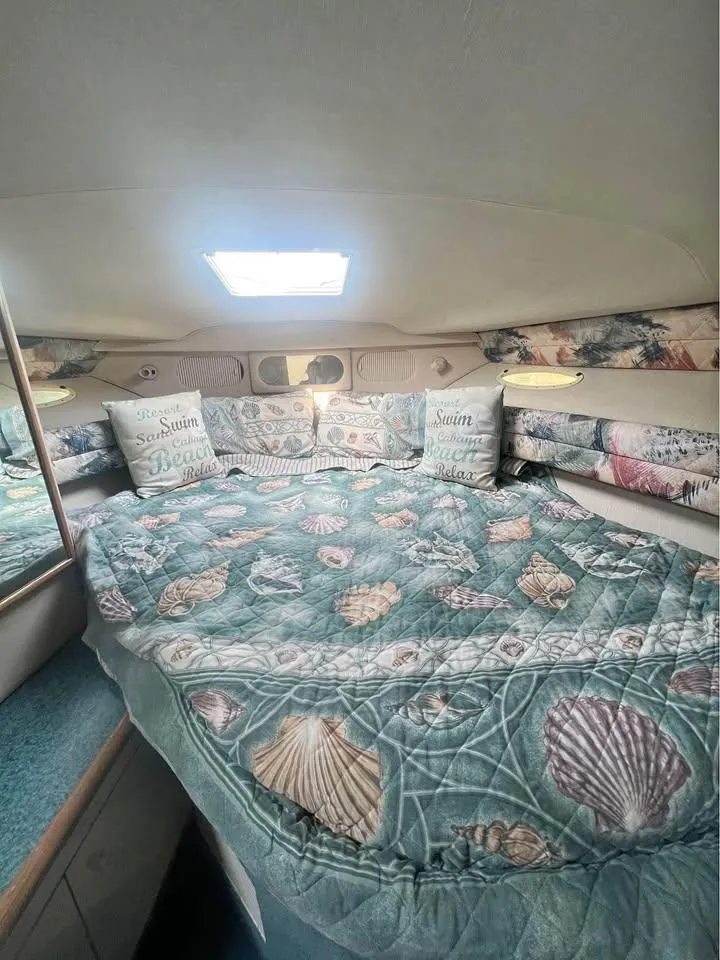 Slide: The Image of Cozy cabin interior of 1995 Sea Ray 330 Sundancer with seashell-themed bedding. - 12