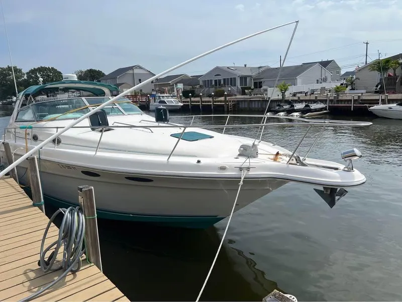 Slide: The Image of 1995 Sea Ray 330 Sundancer docked at a marina, showcasing sleek design and spacious deck. - 2