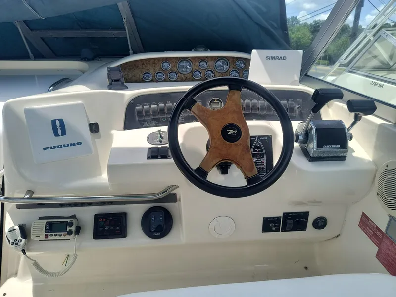 Slide: The Image of 1995 Sea Ray 330 Sundancer helm with steering wheel, gauges, and navigation equipment. - 9