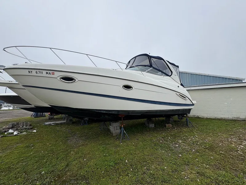 The Image of 2004 Maxum 3100 SE boat on stands, displayed outdoors on grass. - 0