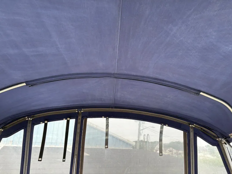 Slide: The Image of Blue canvas canopy of a 2004 Maxum 3100 SE boat, featuring metal support frames. - 11