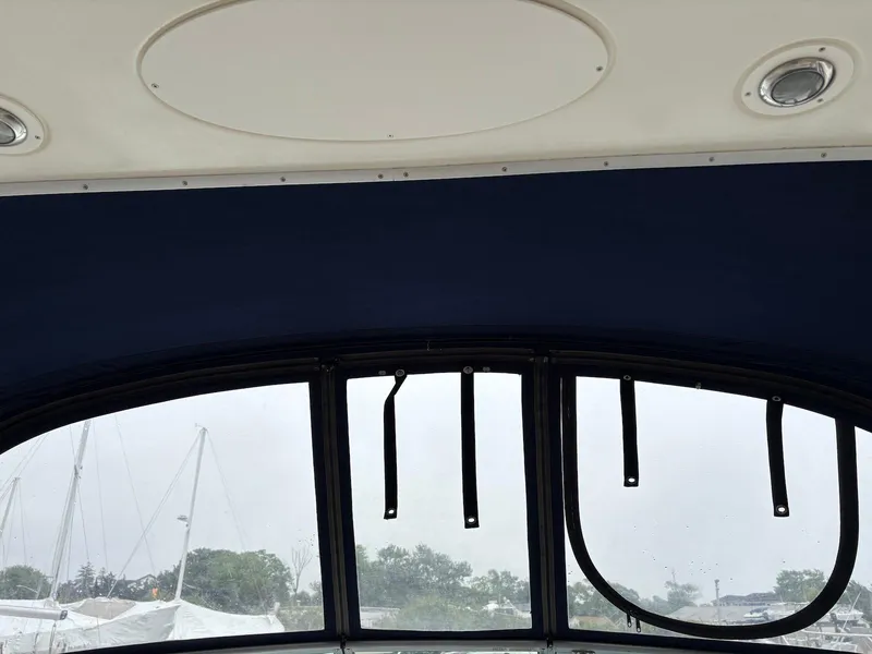 Slide: The Image of Interior view of a 2004 Maxum 3100 SE boat with blue canopy and windows. - 14