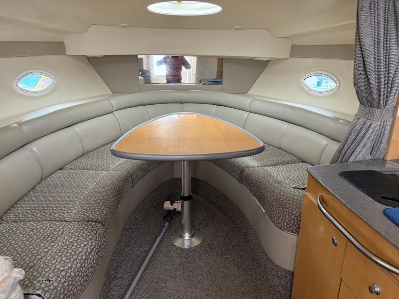 Slide: The Image of 2004 Maxum 3100 SE boat interior with curved seating and wooden table. - 15