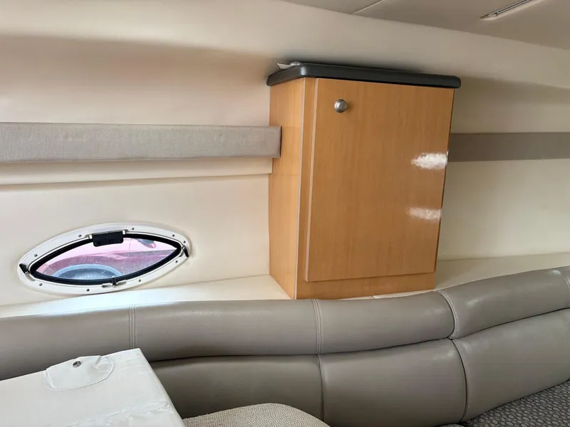 Slide: The Image of 2004 Maxum 3100 SE cabin interior with wooden cabinet and oval window. - 19