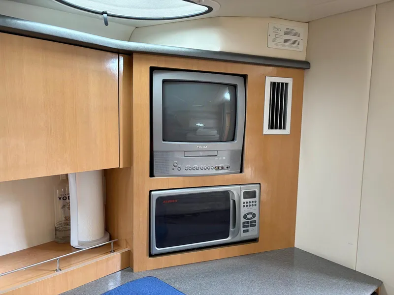 Slide: The Image of 2004 Maxum 3100 SE interior with built-in TV and microwave. - 20