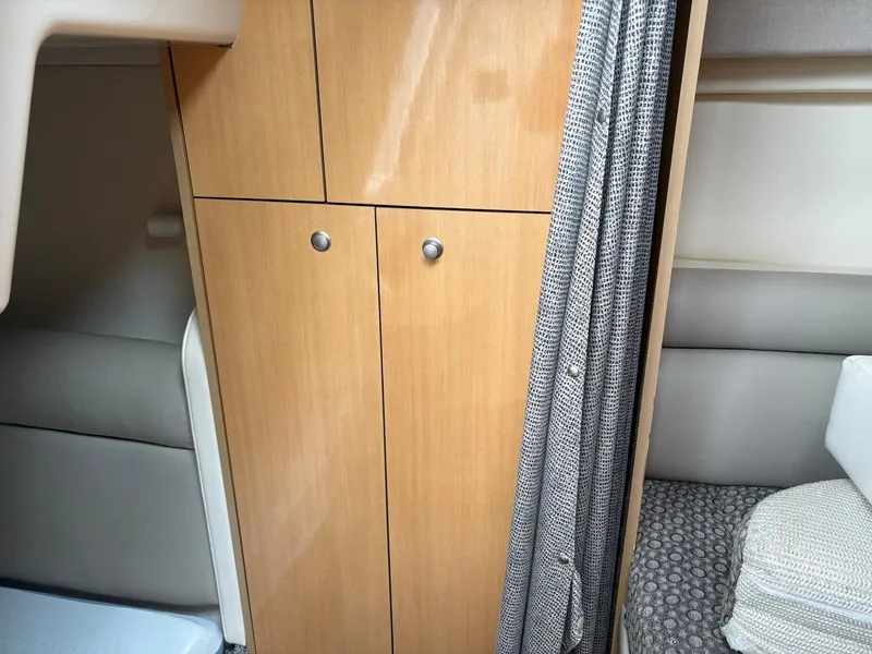 Slide: The Image of 2004 Maxum 3100 SE cabin interior with wooden cabinet and cozy seating area. - 21
