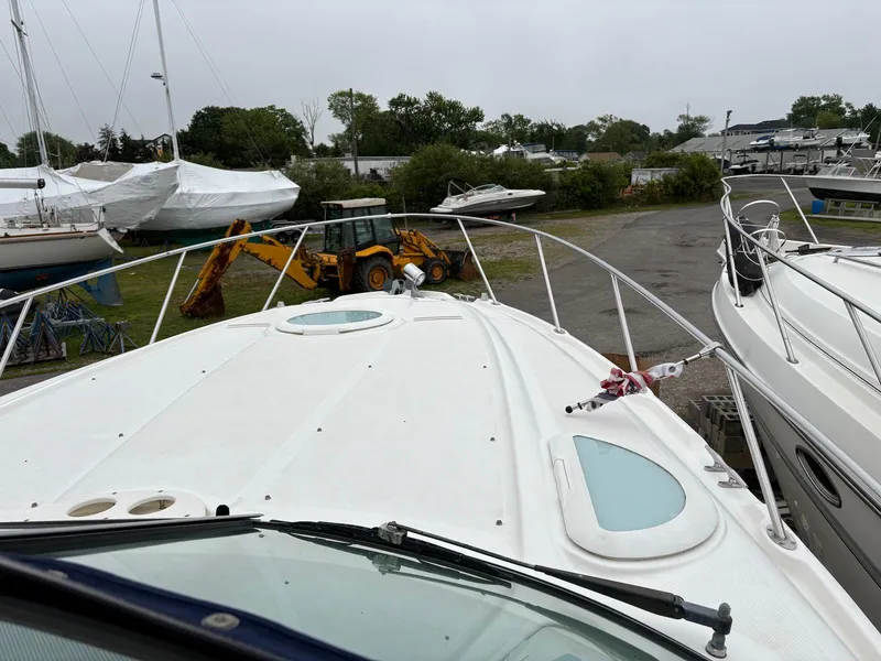 Slide: The Image of 2004 Maxum 3100 SE boat docked near construction equipment and other boats. - 4