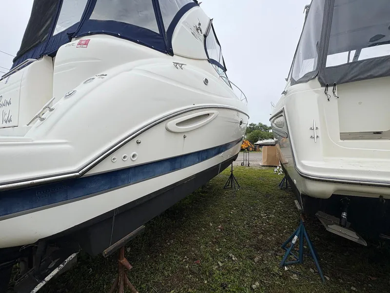 Slide: The Image of 2004 Maxum 3100 SE boats on stands, side view, outdoors. - 5