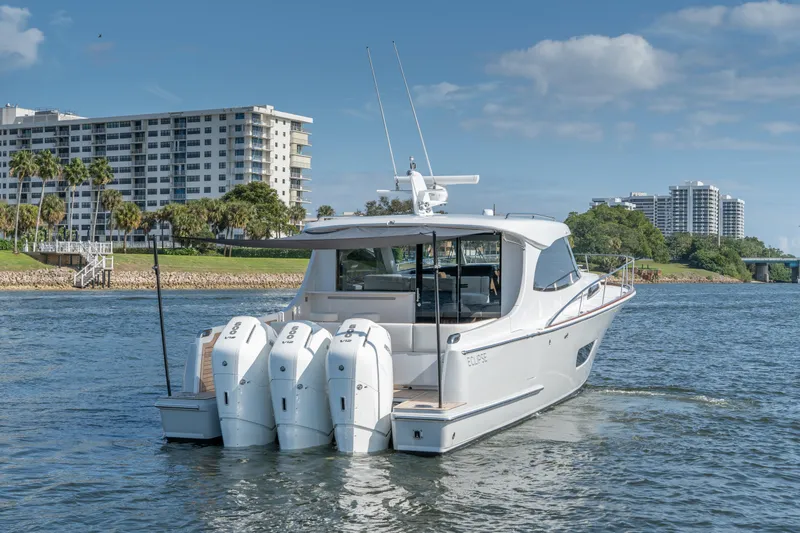 Slide: The Image of Luxury ECLIPSE 505 Shadow yacht on water, 2025 model, with modern buildings in background. - 3