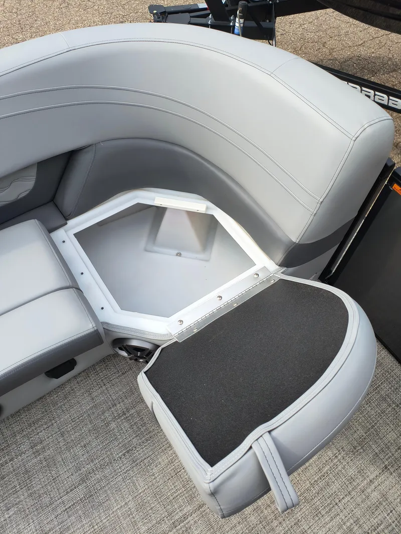 Slide: The Image of 2025 SunCatcher Fusion 322C boat seat with open storage compartment, gray upholstery. - 16