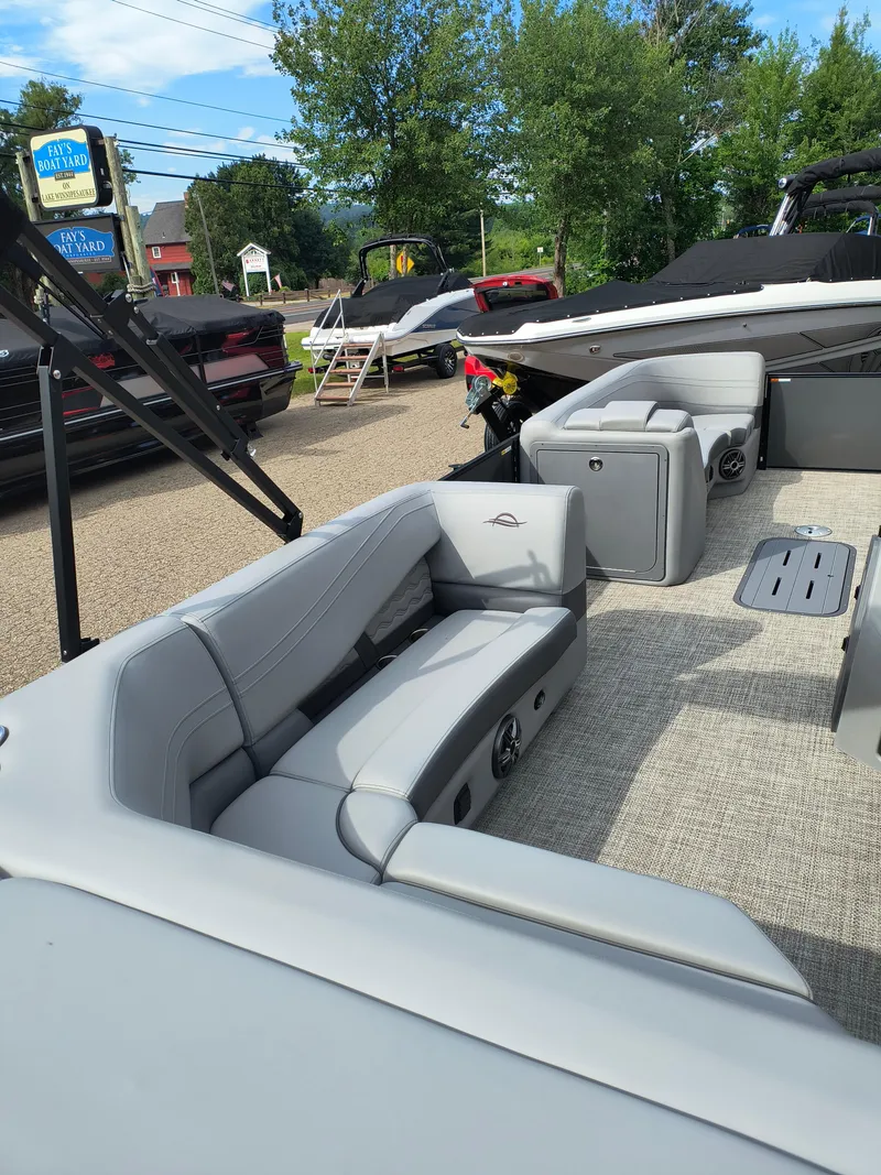 Slide: The Image of 2025 SunCatcher Fusion 322C boat interior with gray seating and outdoor setting. - 19