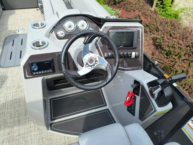 Slide: The Image of 2025 SunCatcher Fusion 322C boat dashboard with steering wheel and control panel. - 26