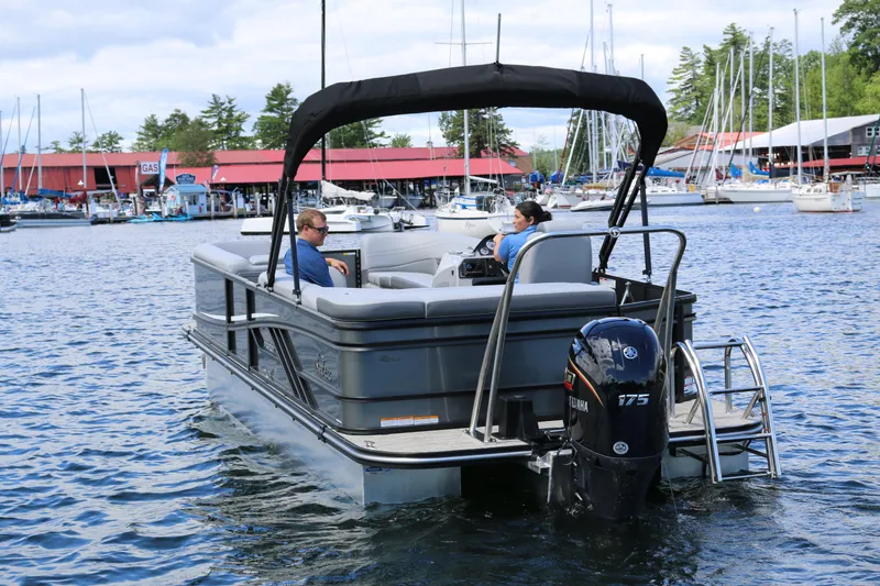 Slide: The Image of 2025 SunCatcher Fusion 322C pontoon boat on water near marina. - 3