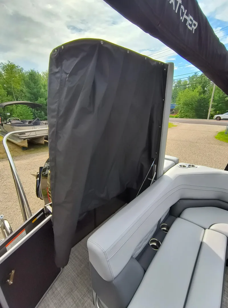 Slide: The Image of 2025 SunCatcher Fusion 322C boat interior with seating and privacy curtain. - 30
