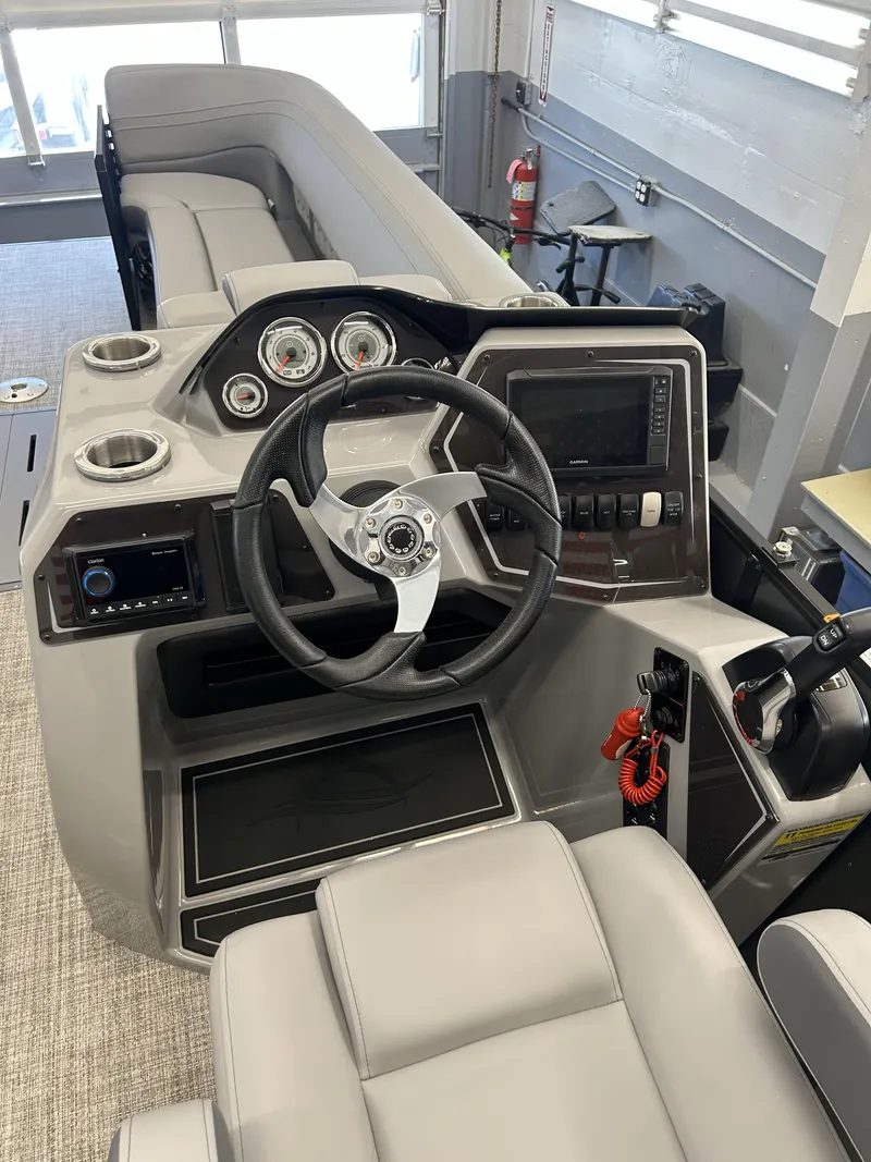 Slide: The Image of 2025 SunCatcher Fusion 322C boat interior with steering wheel and control panel. - 7