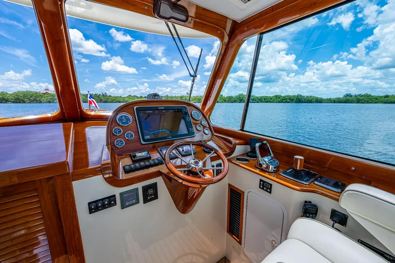 Slide: The Image of 2016 Hinckley Picnic Boat 37 MKIII helm with wooden dashboard and scenic water view. - 11