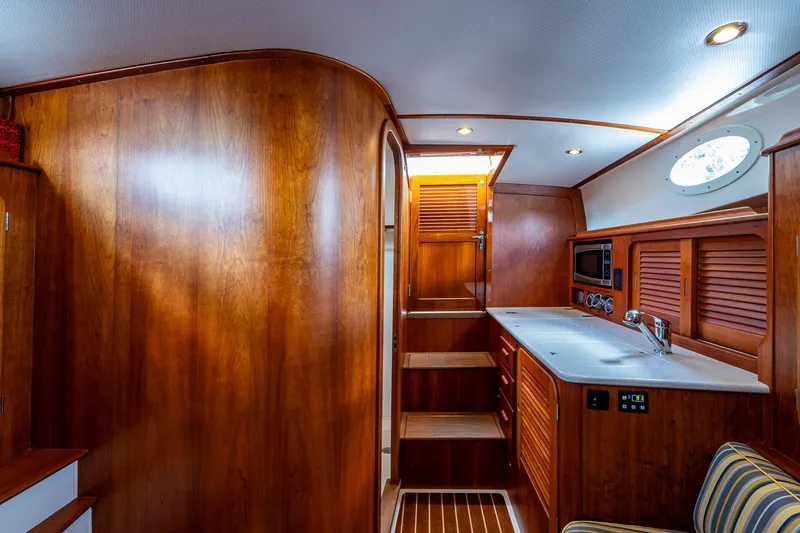 Slide: The Image of Interior of 2016 Hinckley Picnic Boat 37 MKIII with wooden cabinetry and modern amenities. - 12