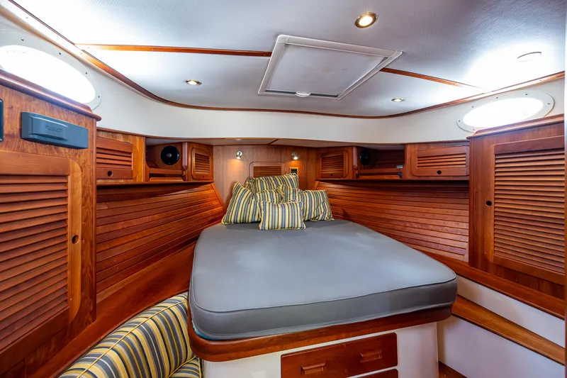 Slide: The Image of Luxurious cabin interior of 2016 Hinckley Picnic Boat 37 MKIII with wood finish and cozy bedding. - 15