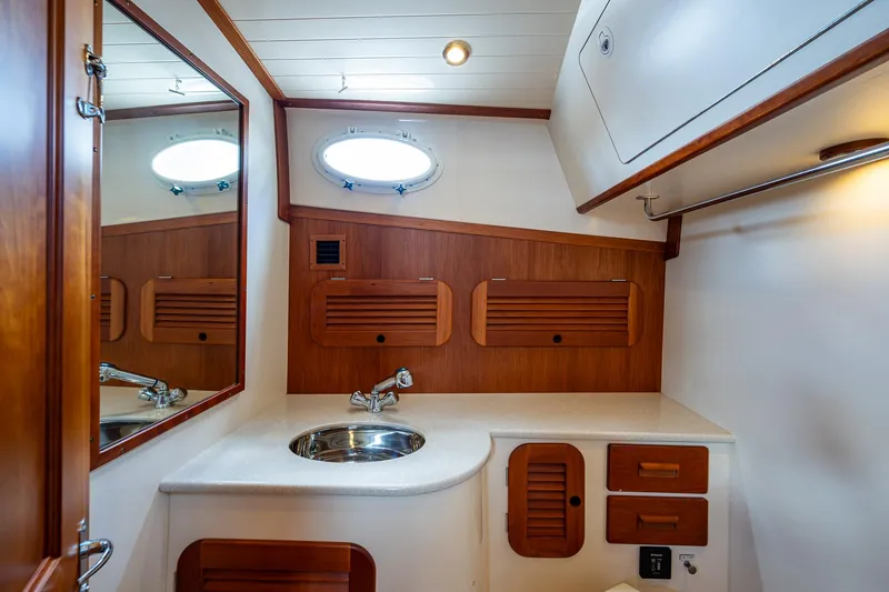 Slide: The Image of 2016 Hinckley Picnic Boat 37 MKIII bathroom with wooden cabinetry and stainless steel sink. - 16
