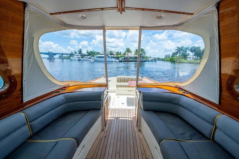 Slide: The Image of 2016 Hinckley Picnic Boat 37 MKIII interior with waterfront view, featuring elegant seating and wood finishes. - 17