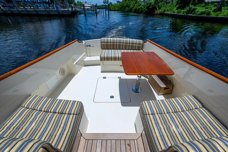 Slide: The Image of 2016 Hinckley Picnic Boat 37 MKIII with striped seating and wooden table on deck. - 18