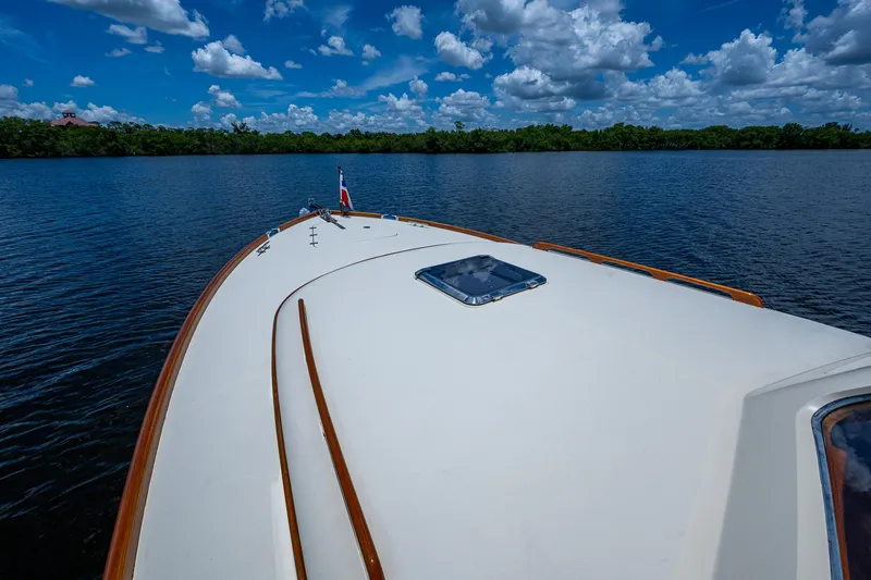 Slide: The Image of 2016 Hinckley Picnic Boat 37 MKIII cruising on a serene lake under a blue sky. - 22