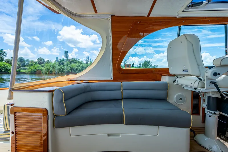 Slide: The Image of Interior of 2016 Hinckley Picnic Boat 37 MKIII with seating and helm, overlooking scenic waterway. - 7