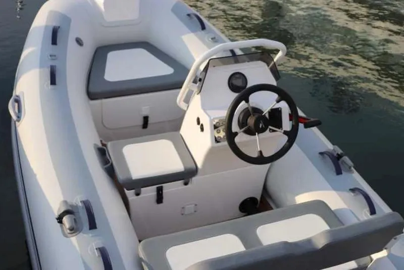 Slide: The Image of 2024 Highfield Classic 340 GT boat interior with steering console and seating on water. - 4