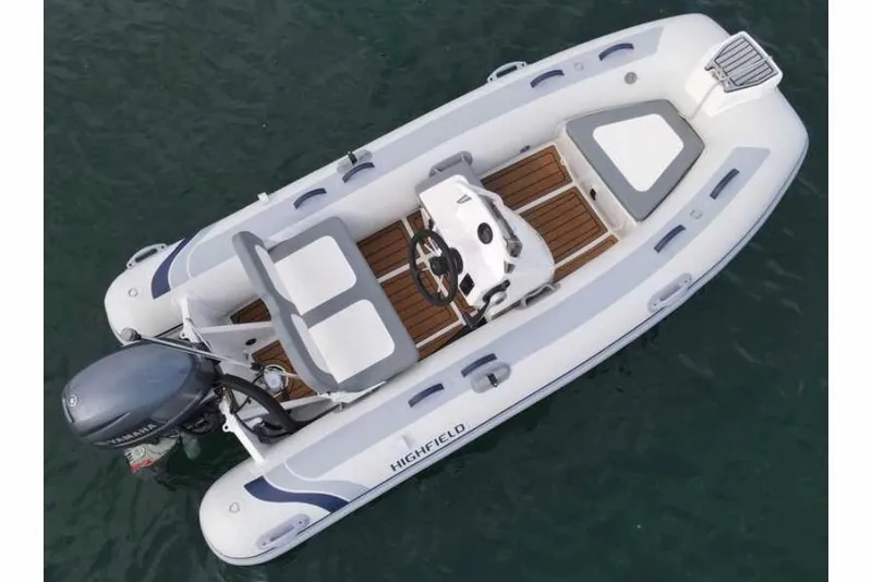 Slide: The Image of 2024 Highfield Classic 340 GT boat, aerial view, white and gray design, wooden deck, outboard motor. - 5