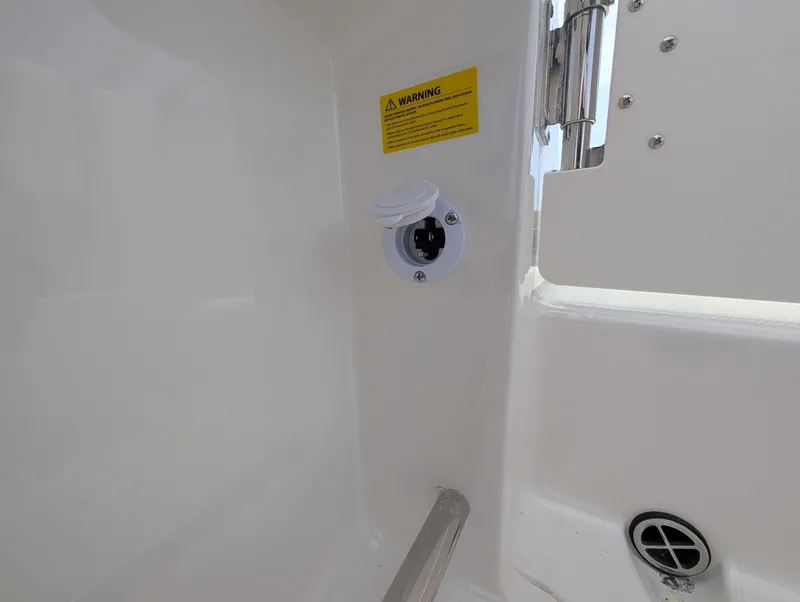 Slide: The Image of 2025 Robalo R222 Explorer boat interior detail with warning label and power socket. - 36
