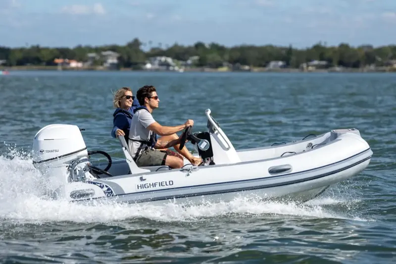 The Image of 2024 Highfield Classic 360 GT boat cruising on a sunny day with two passengers. - 0