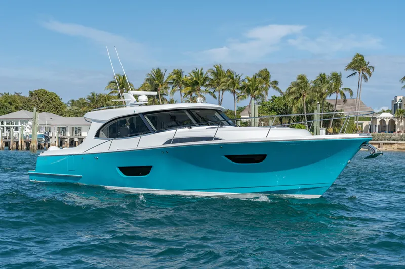 Slide: The Image of 2025 ECLIPSE 505 Shadow yacht on blue water with palm trees in background. - 1