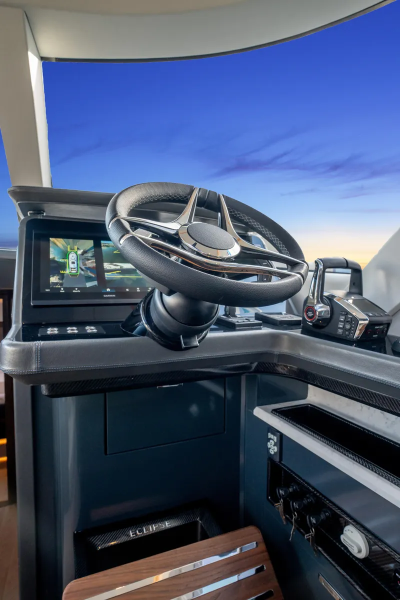 Slide: The Image of Steering wheel of 2025 ECLIPSE 505 Shadow boat against a sunset sky. - 6