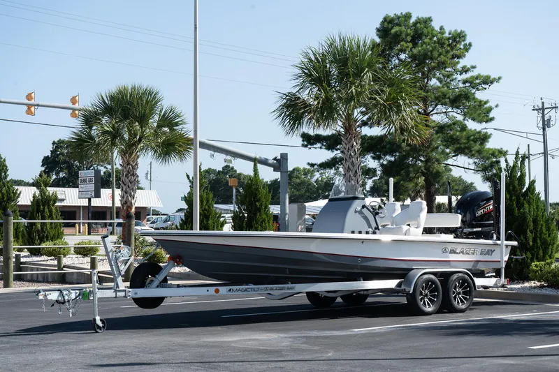 The Image of 2026 Blazer 675 Ultimate Bay boat on trailer, parked near palm trees. - 0