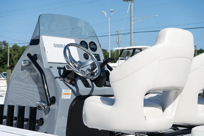 Slide: The Image of 2026 Blazer 675 Ultimate Bay boat interior with white seats and modern dashboard. - 11